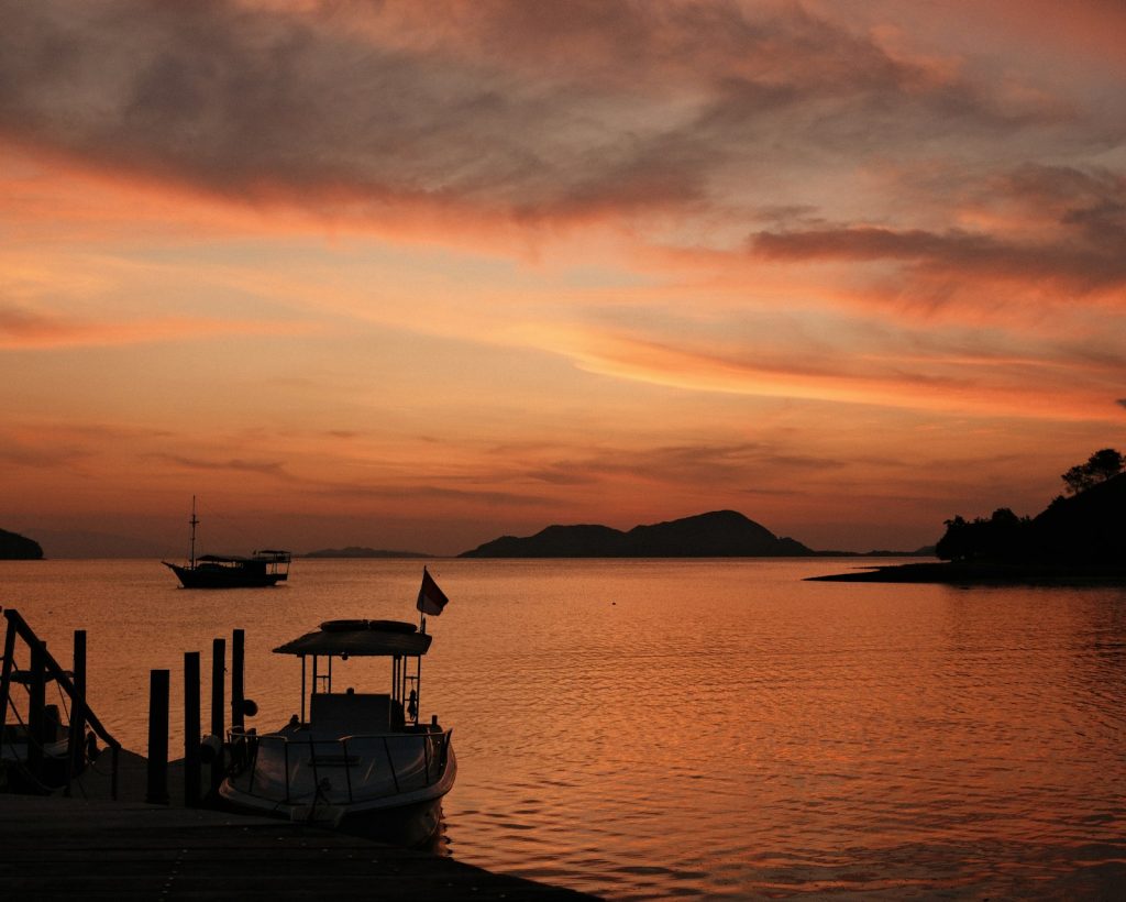A boat sitting on top of a body of water under a cloudy sky